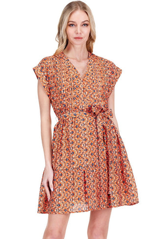 orange geometric print mini dress with V-neckline, pin tuck detailing, cap sleeves, and self-tie belt at waist