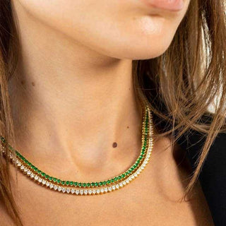 Close-up of a person wearing a green and gold beaded necklace.