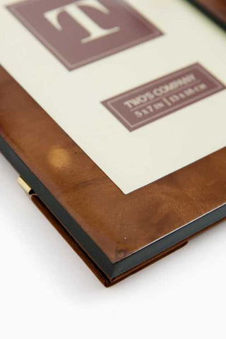 Close-up of a leather-bound book with a visible brand name on a white background