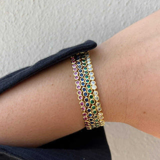 Multicolored beaded bracelet on a wrist against a neutral background