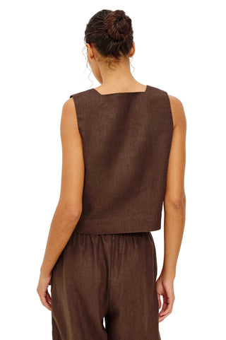 Person wearing a brown sleeveless top and pants on a white background