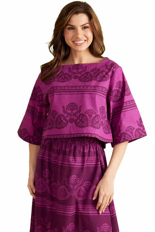Purple paisley print kimono sleeve top with garden motif pattern and elastic waist worn by smiling woman