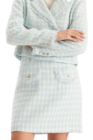 Tyler Boe Ashley Boucle Skirt in Above the Cloud. Light blue and cream houndstooth bouclé mini skirt with patch pockets, pearl button details, and fringe trim