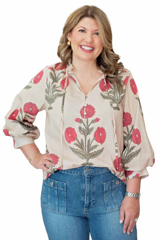 Entro Ava Top. Woman wearing cream blouse with red floral print and high-waisted blue jeans