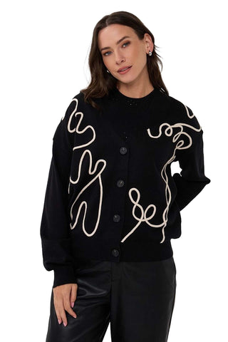 Esqualo Cardigan Tape Patch in Black. Black cardigan with cream abstract rope-like piping creating 3D sculptural design, button front, and crew neck