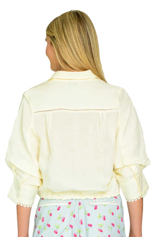 Woman wearing a light yellow jacket with a white background