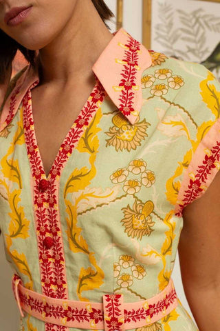 Close-up of a person wearing a colorful embroidered top with floral patterns.