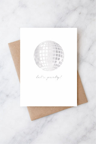 Card with disco ball and 'let's party!' text on a marble surface