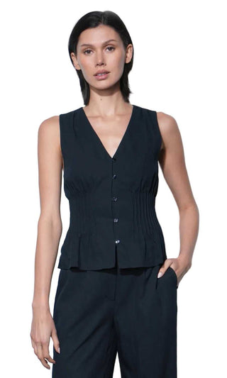 Woman wearing a black sleeveless top and pants against a white background