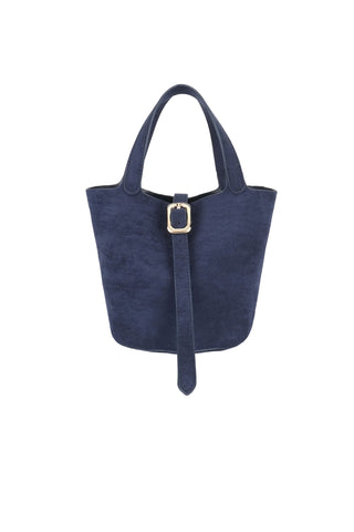 Remi Reid Joya Mini Faux Suede Bag in Navy. Navy blue faux suede mini bucket bag with dual top handles, gold rectangular buckle detail, and adjustable strap closure