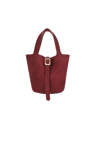 Remi Reid Joya Bucket Mini Faux Suede Bag - Wine. Wine burgundy faux suede mini bucket bag with dual top handles, gold rectangular buckle detail, and adjustable strap closure
