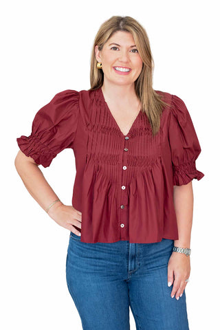 
Entro Kyla top featuring smocked bodice detail, gathered puff sleeves, V-neckline and button-front closure available in chestnut and burgundy colors