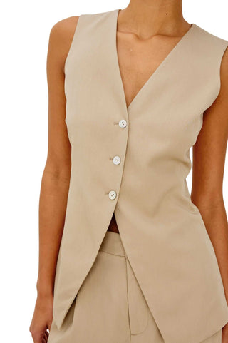 Beige sleeveless vest worn by a person on a white background