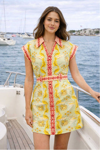Woman in a patterned dress on a boat with water and sky in the background