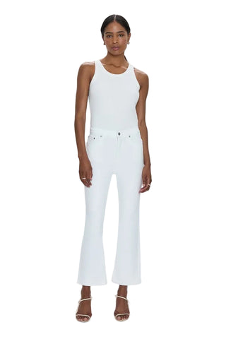 Woman wearing a white sleeveless top and white pants on a white background