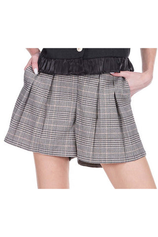 Grey and white houndstooth plaid tailored shorts with front pleats and elastic back waist on white background
