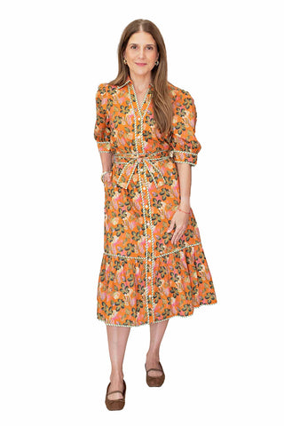 THML Quinn Midi Dress. Orange midi dress with colorful floral print, wrap-style bodice, tie belt, three-quarter sleeves, and tiered hem 