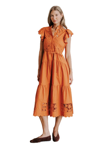 Love the Label Romy Dress in Cinnamon. Burnt orange midi dress with flutter sleeves, lace bodice detail, tie waist, tiered skirt, and scalloped eyelet hem