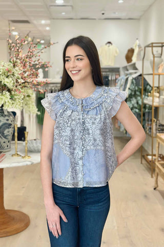 Woman wearing a blue floral blouse in a store setting