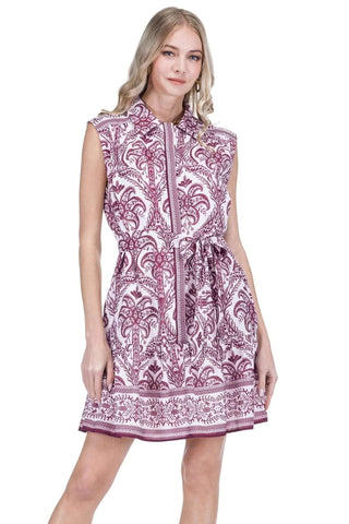 A sleeveless collared dress with a purple and white paisley pattern, featuring a front zipper, drawstring waist, and a flared skirt, shown on a model against a white background.