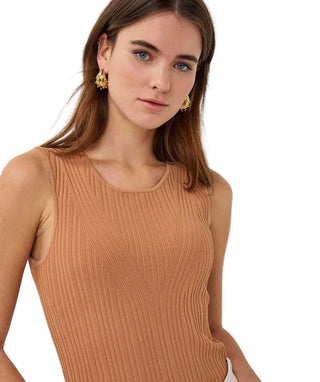 Woman wearing a brown ribbed tank top against a white background
