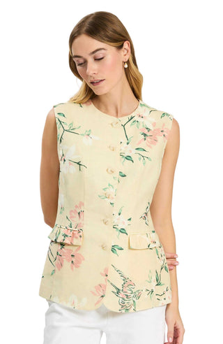 Woman wearing a light yellow sleeveless top with floral pattern on a white background