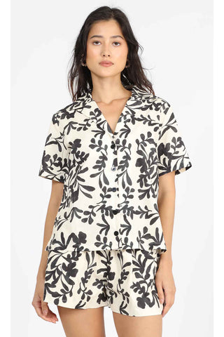 cream shorts with black botanical leaf print, featuring drawstring waist and relaxed fit, paired with matching printed shirt"