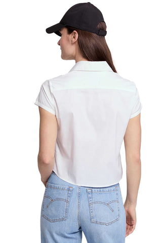 Person wearing a white shirt and light blue jeans with a black cap on a white background
