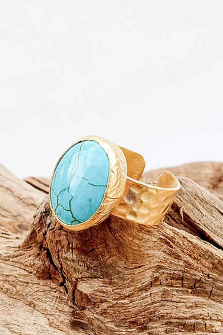 Gold adjustable cuff ring with oval turquoise stone featuring natural veining