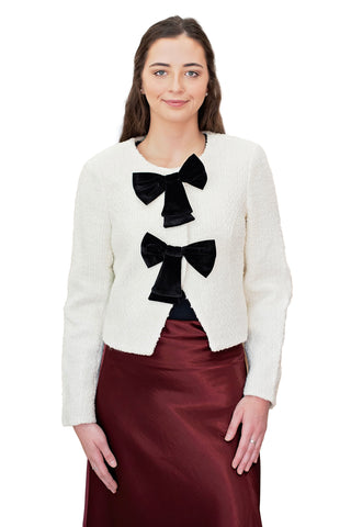 Dolce Cabo Velvet Bow Trimmed Blazer in Creme and Black. Cream textured bouclé cropped jacket with three black velvet bow closures and long sleeves 