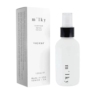 A frosted glass spray bottle with a black collar and clear cap stands next to its white packaging box, both featuring the brand name 'm'ly' and product name 'voyeur'.