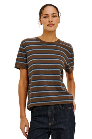 Woman wearing a brown and blue striped t-shirt against a plain background